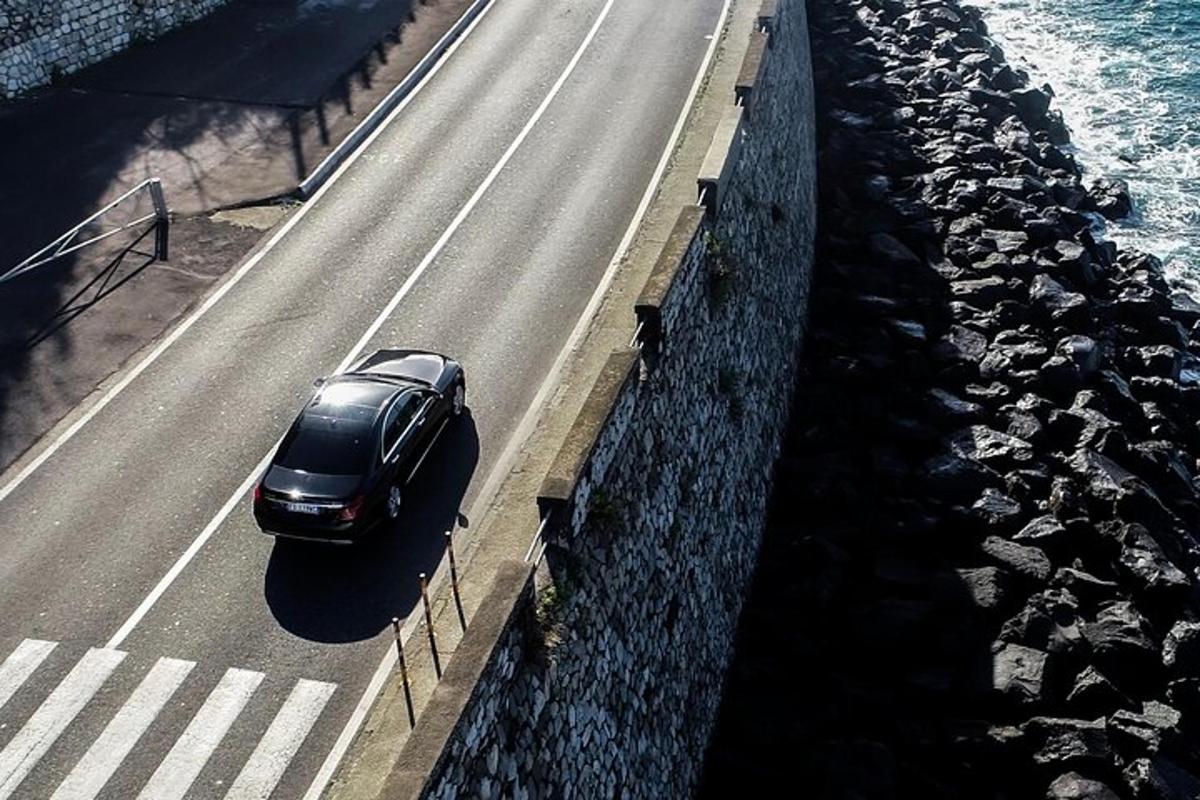 samochód jadący drogą obok wody