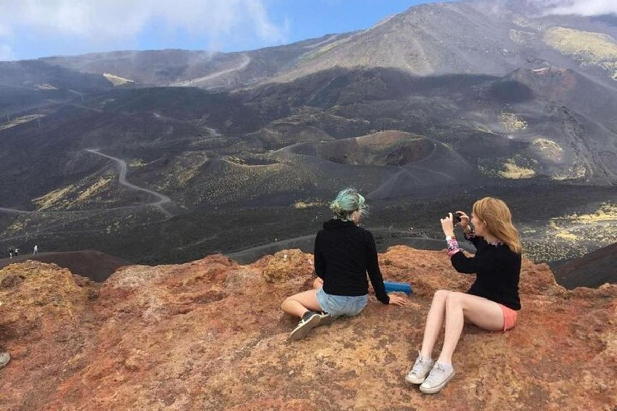 două femei stând pe vârful unui munte și făcând o fotografie