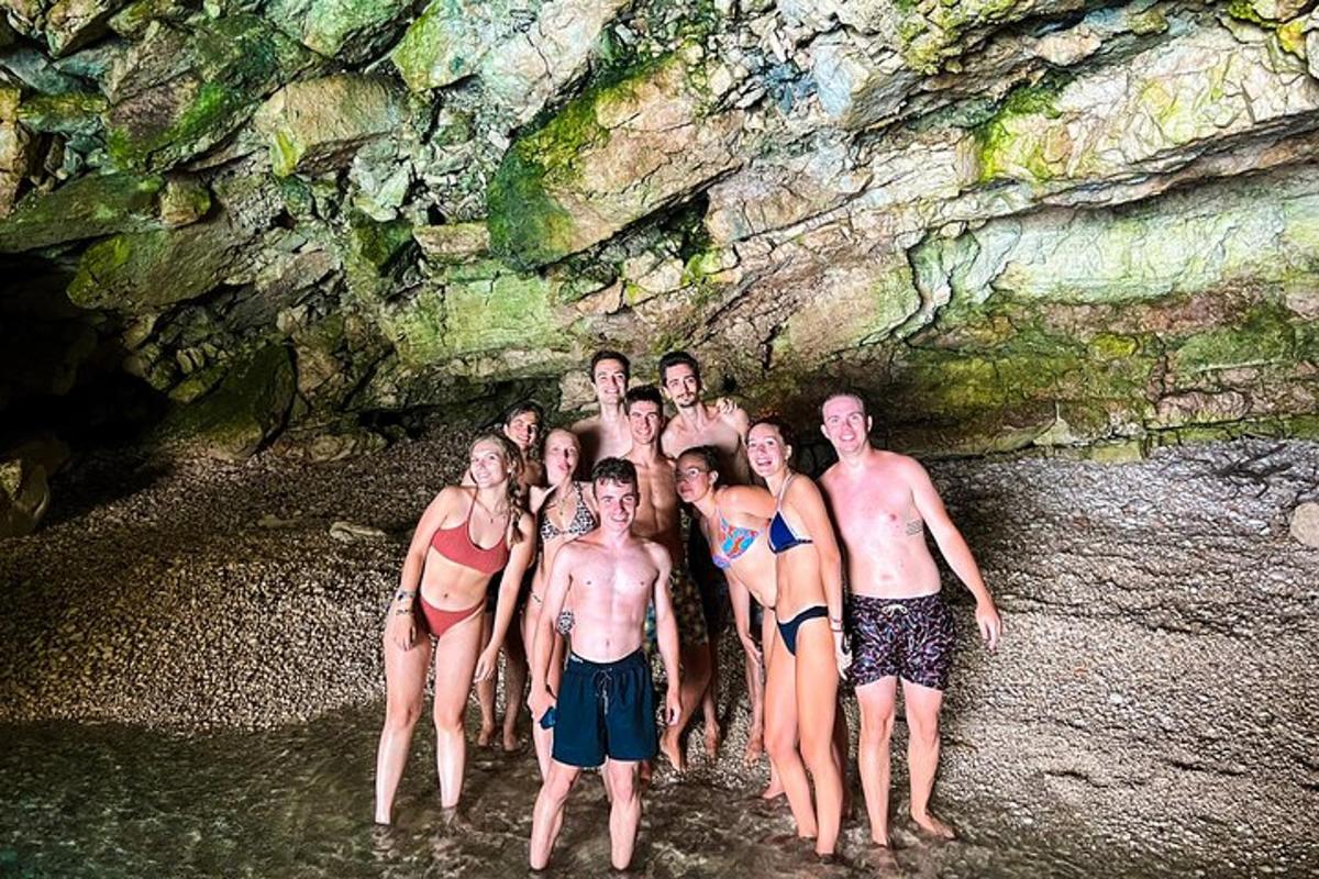 a group of people standing in front of a cave