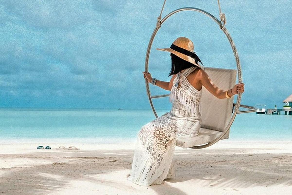 seorang wanita duduk di ayunan di pantai