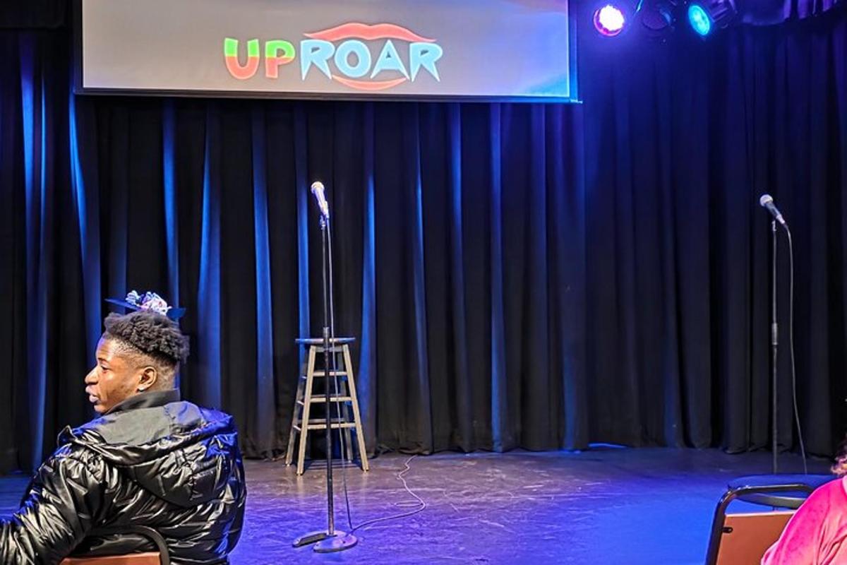 a man sitting on a stage in front of microphones