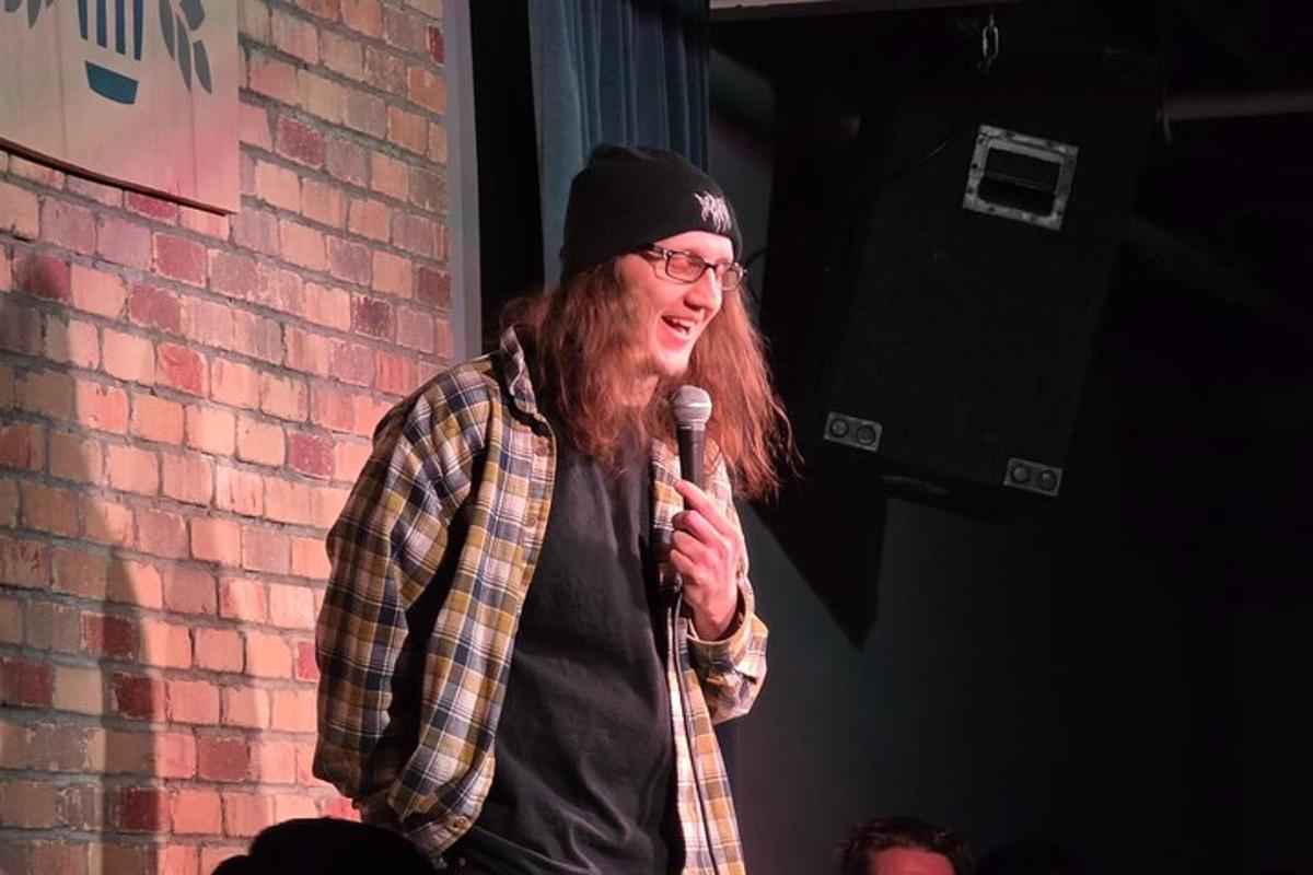 a man holding a microphone in front of a brick wall