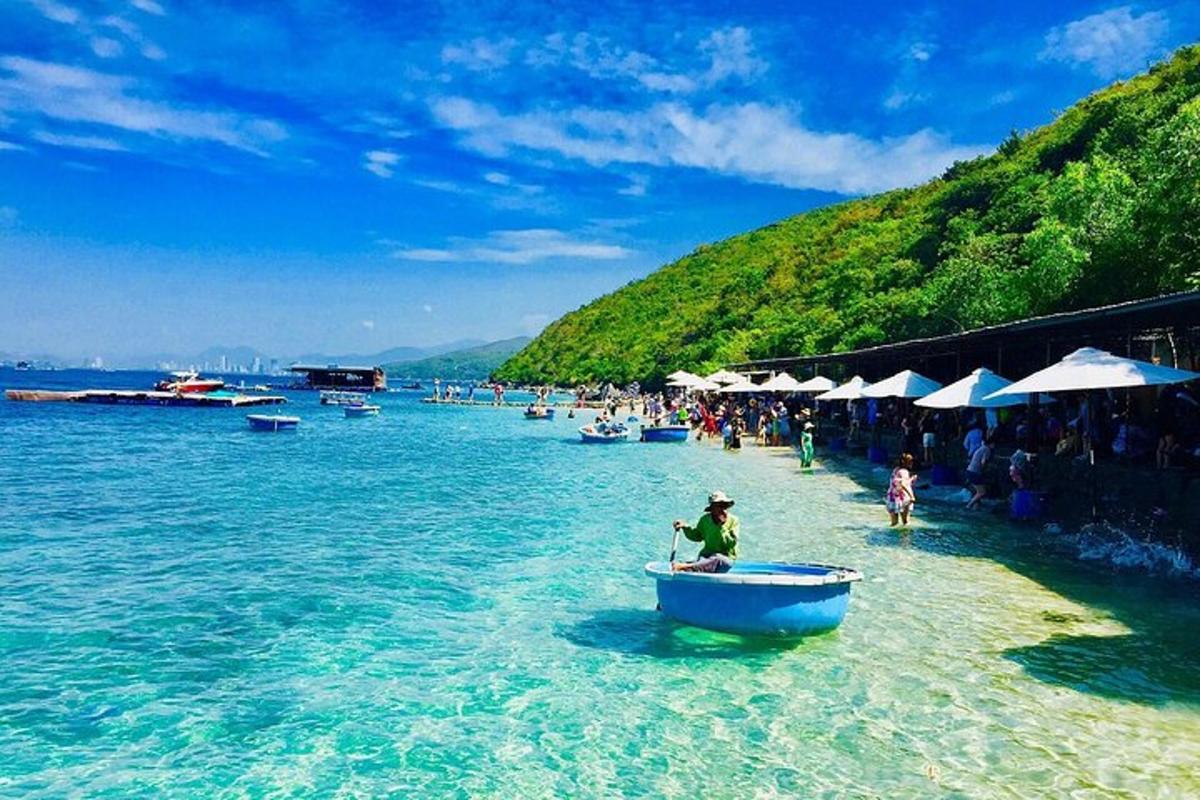 một nhóm người trên bãi biển với một chiếc thuyền trên mặt nước