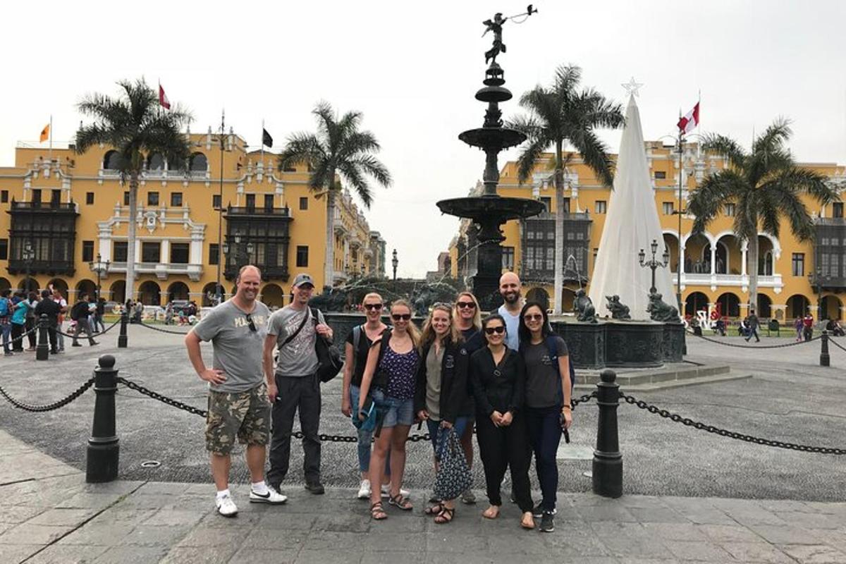 um grupo de pessoas em pé em frente a uma fonte