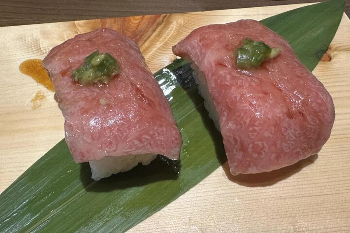 two pieces of meat sitting on a green leaf