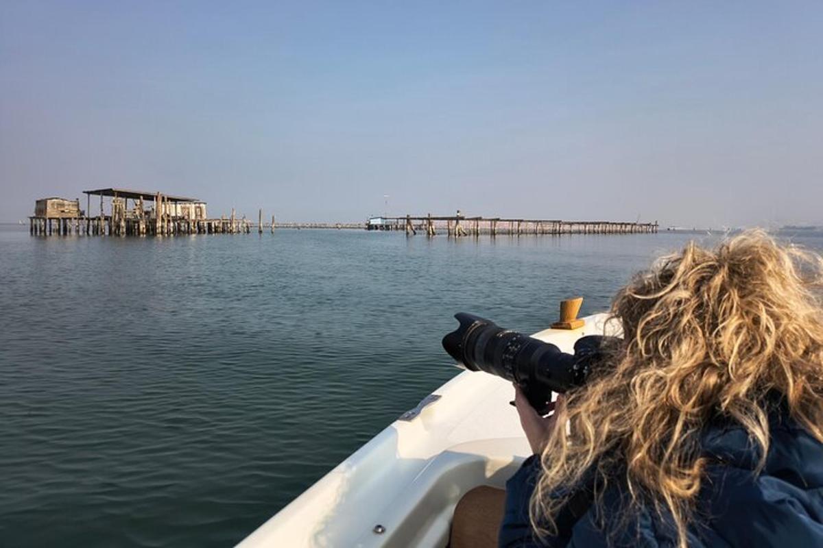 eine Frau, die von einem Boot aus ein Foto von einem Pier macht