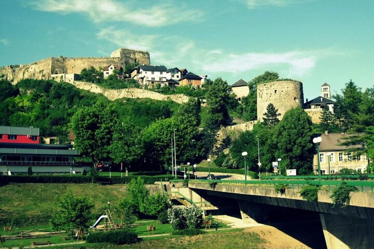 a town with a castle on a hill with a bridge