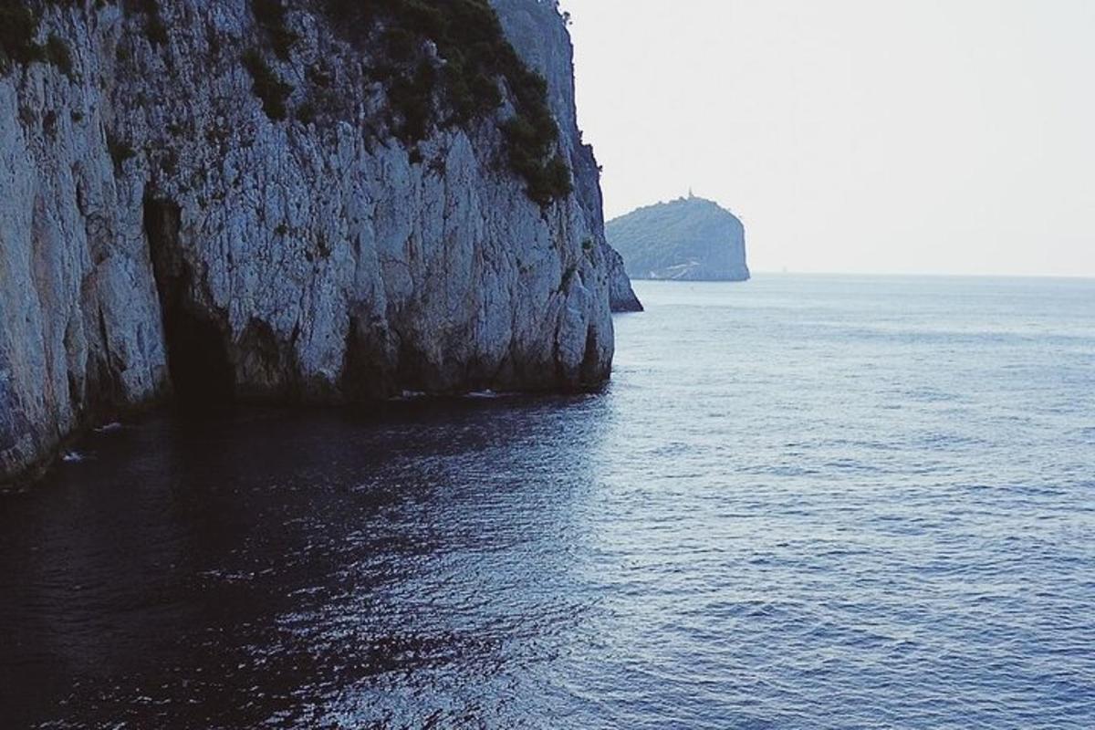 a large body of water next to a rocky cliff