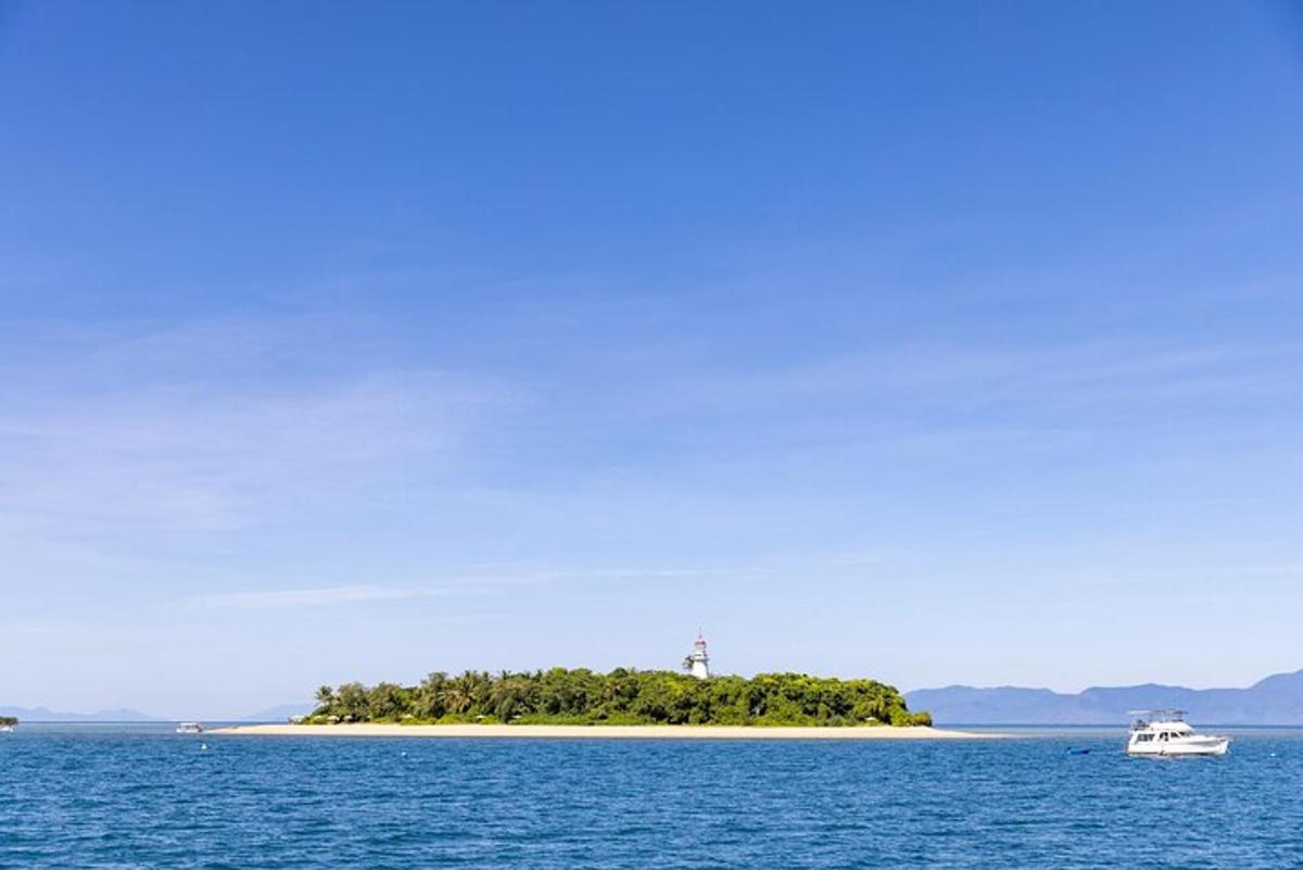 a small island in the ocean with a boat