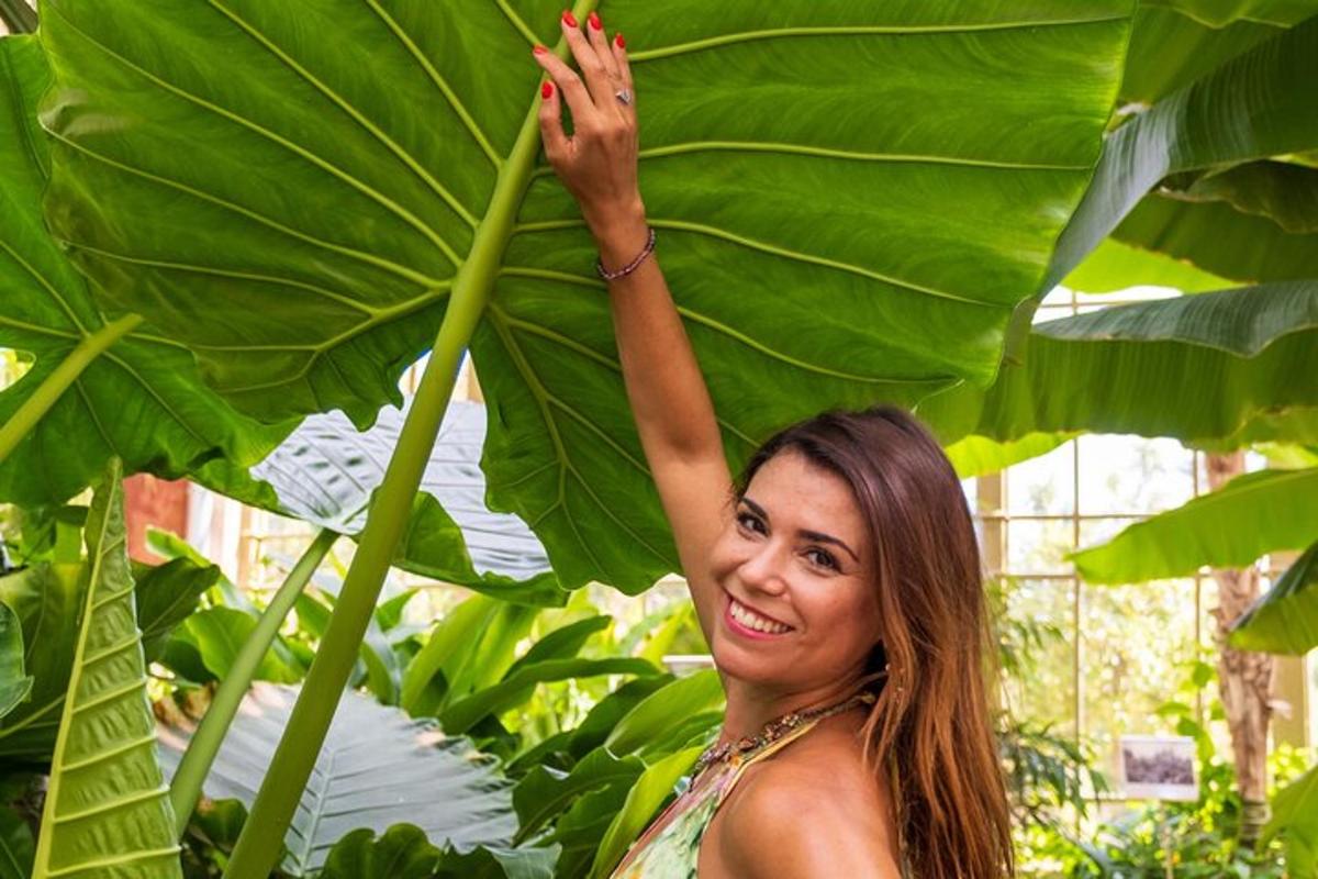 una donna tiene in mano una grande foglia verde