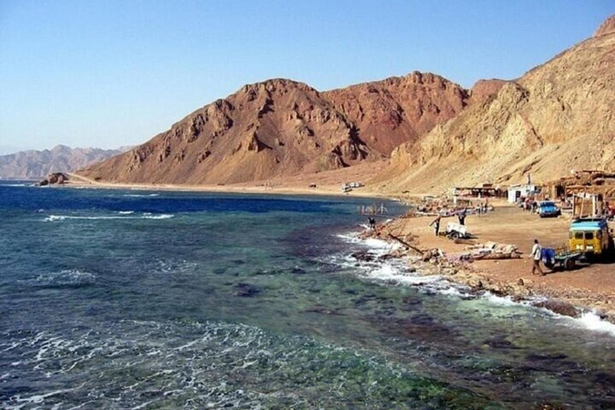 pantai dengan sekumpulan orang dan bas