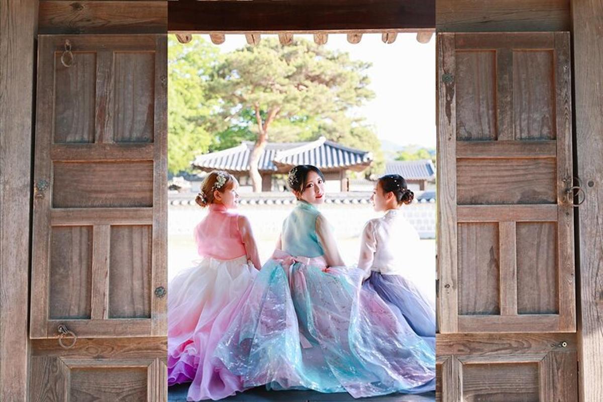 three young girls in dresses sitting in an open door