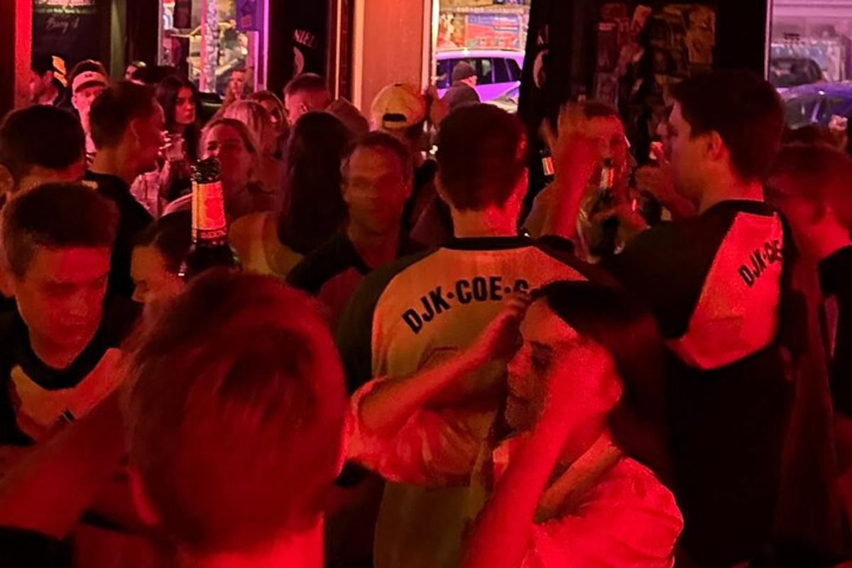 eine Gruppe von Menschen steht in einer Menschenmenge in einer Bar