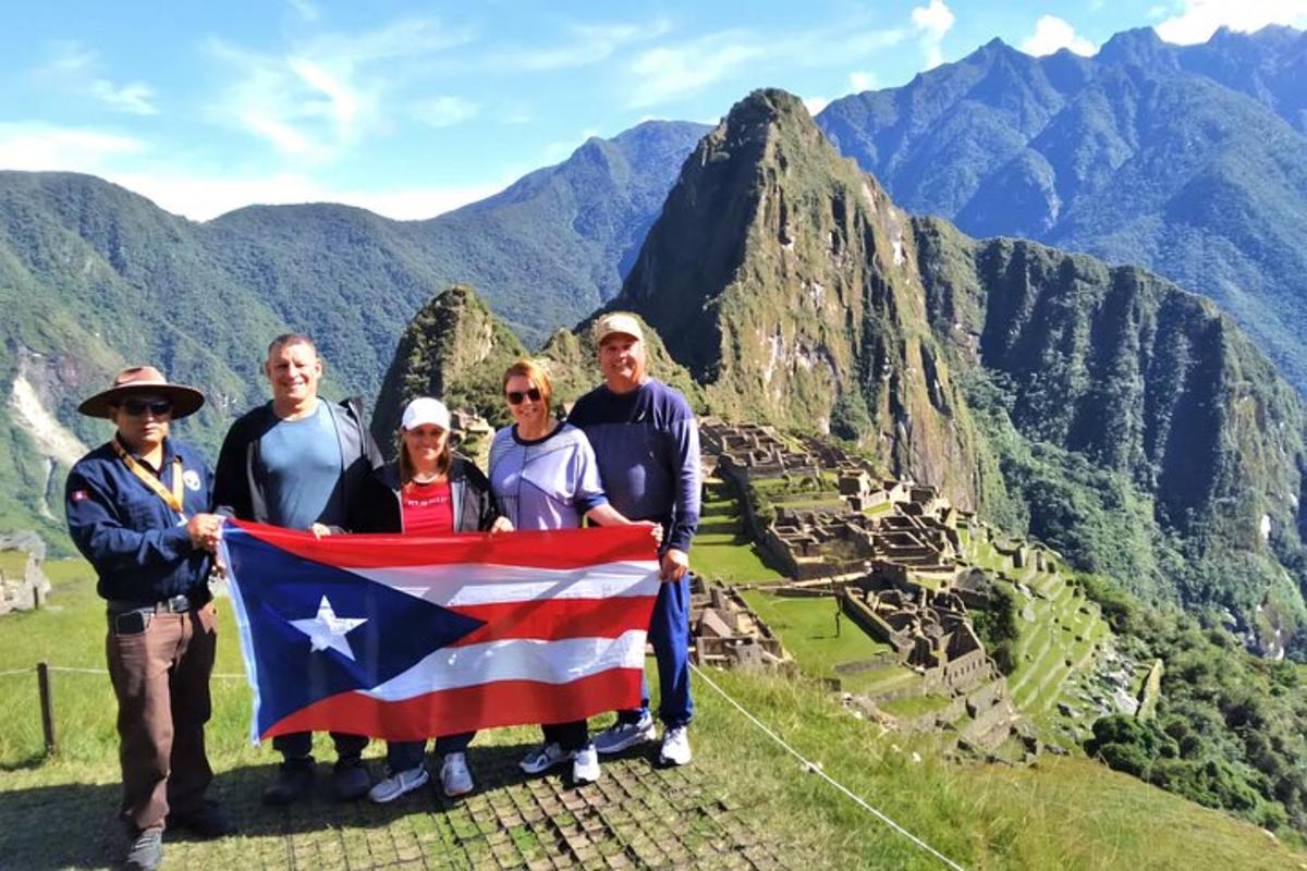 Un grupo de personas sosteniendo una bandera en la cima de una montaña.