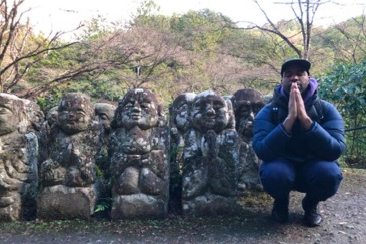 isang lalaking nakaluhod sa harap ng isang estatwa ng ulong bato