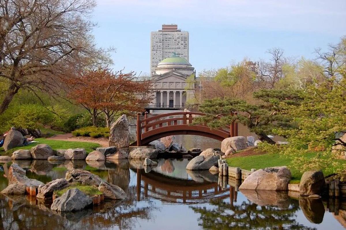 a bridge over a pond in a park with a building