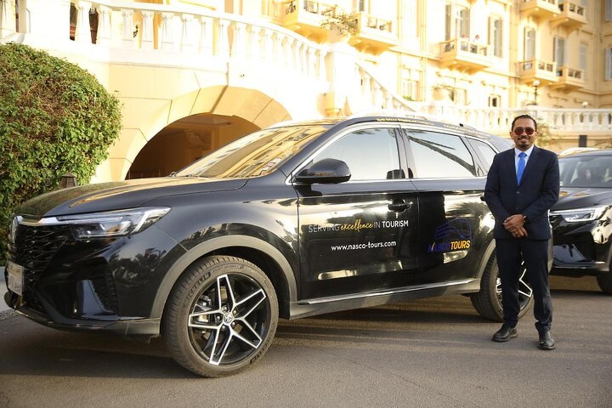seorang lelaki berpakaian sut berdiri di sebelah kereta