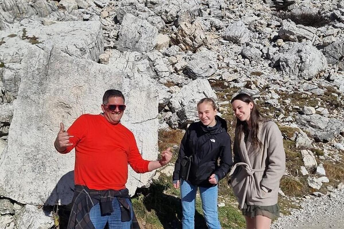 un gruppo di tre persone in piedi accanto a una roccia