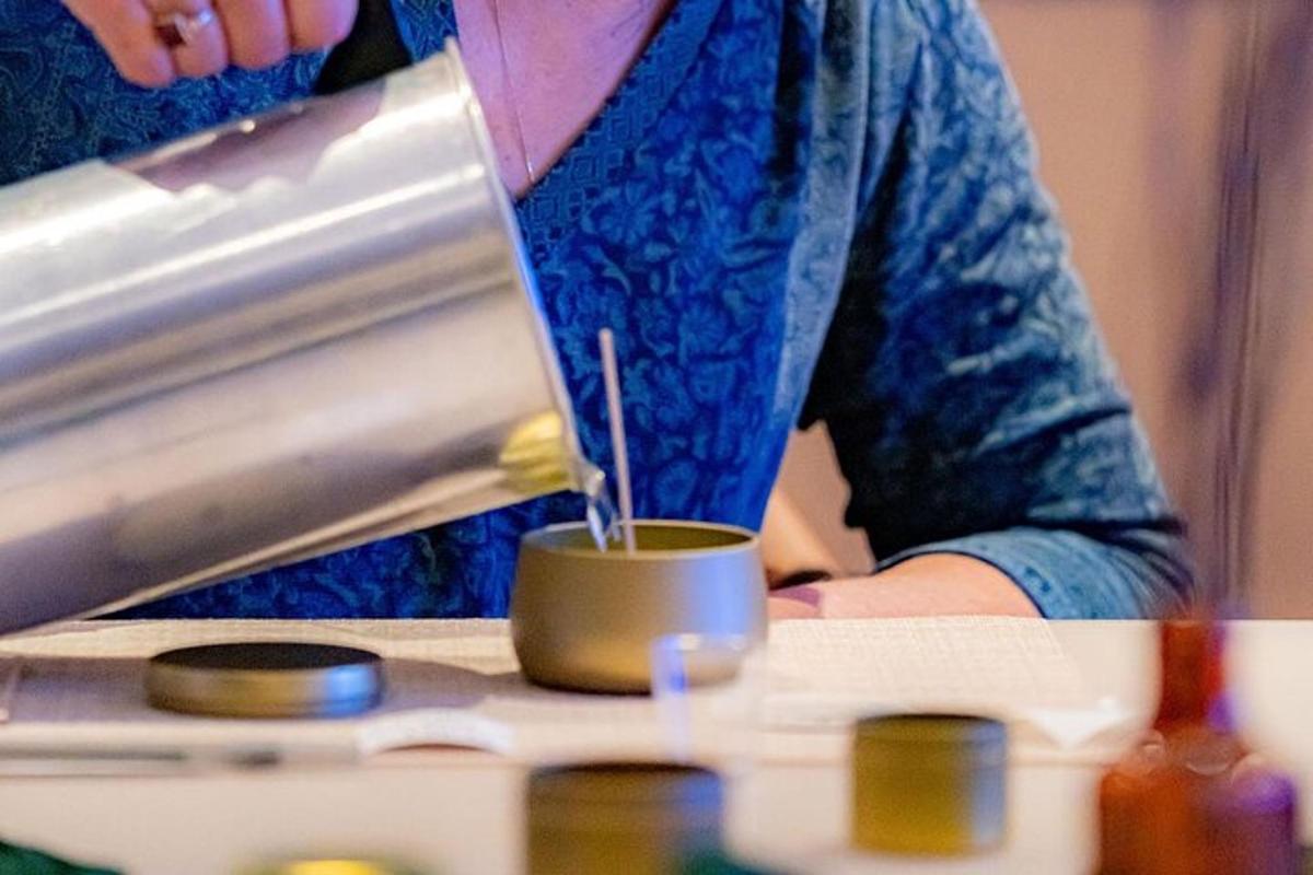 a woman in a blue shirt is making a cup