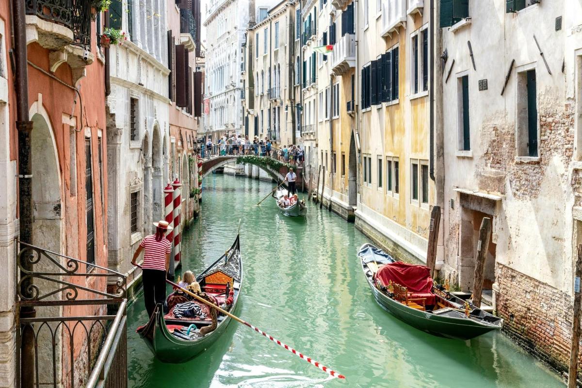 un grup de gòndoles en un canal entre dos edificis