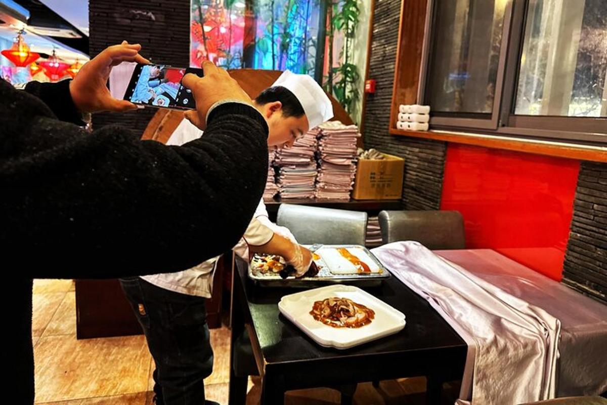 una donna che scatta una foto a un uomo che mangia cibo