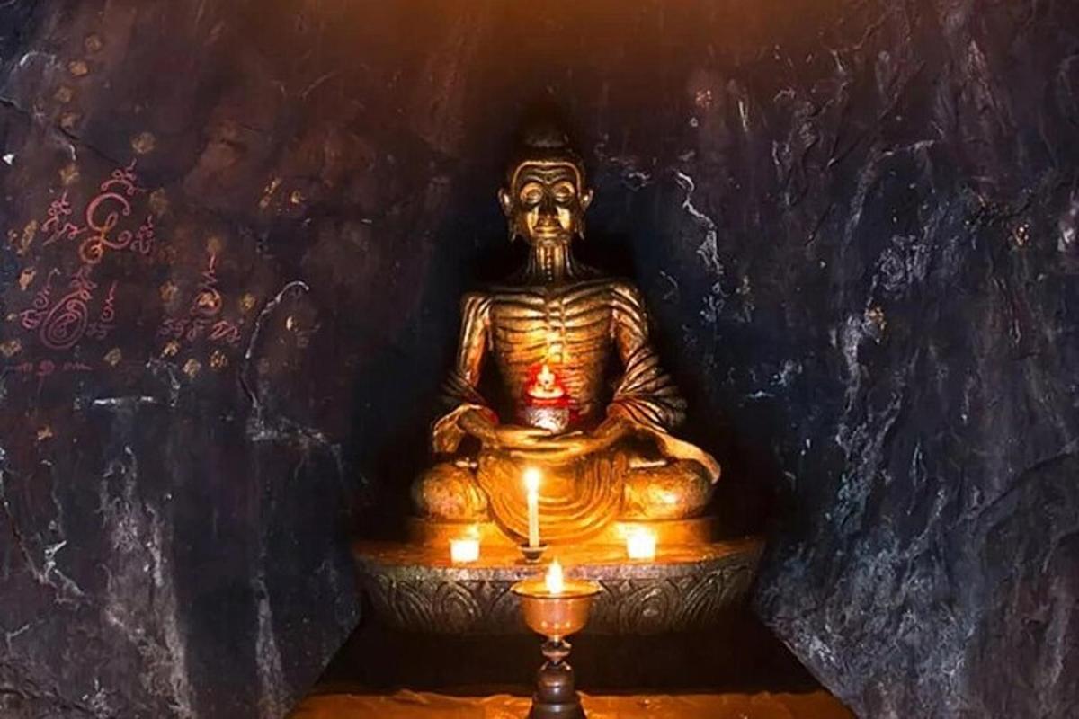a gold statue with candles in a room