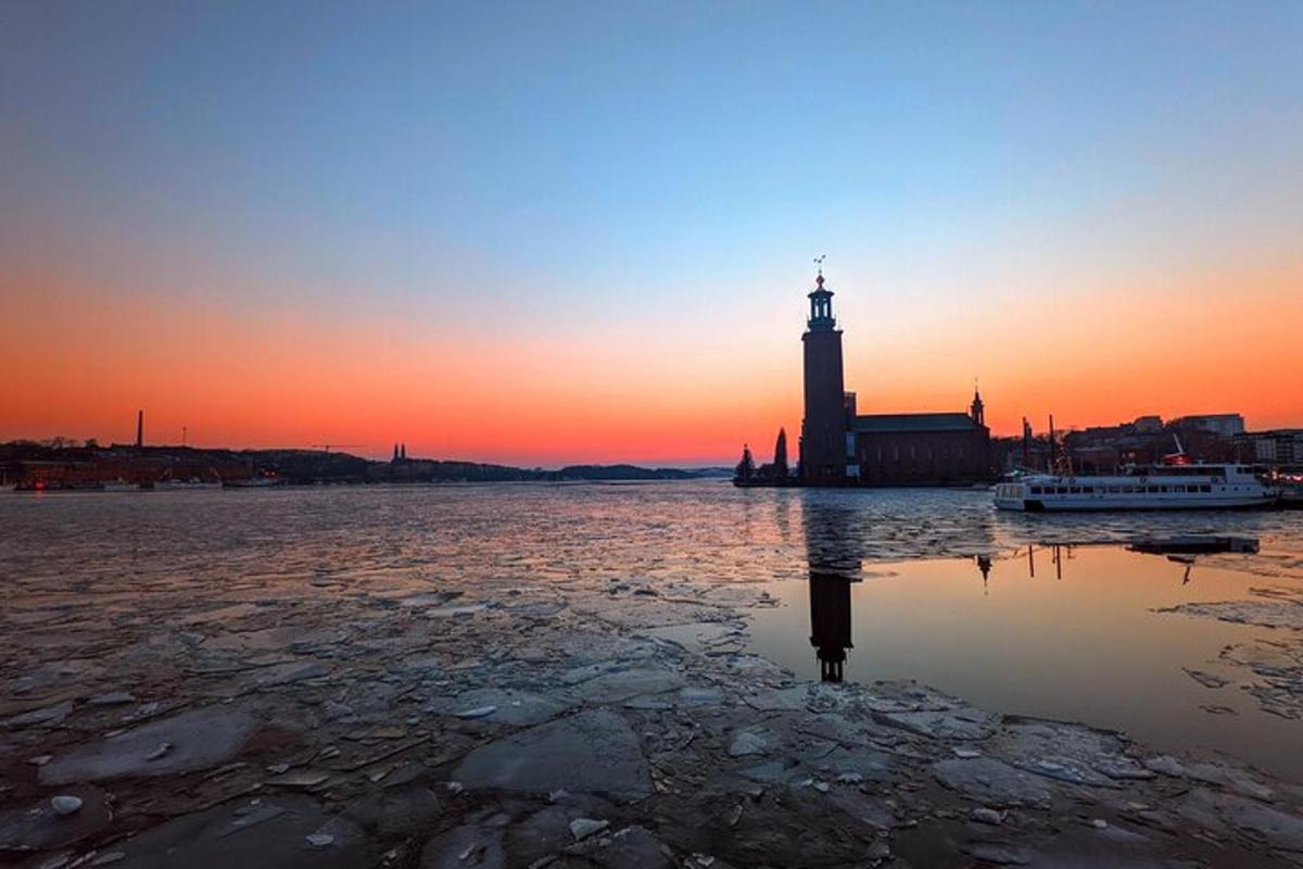 a lighthouse in the middle of the water at sunset