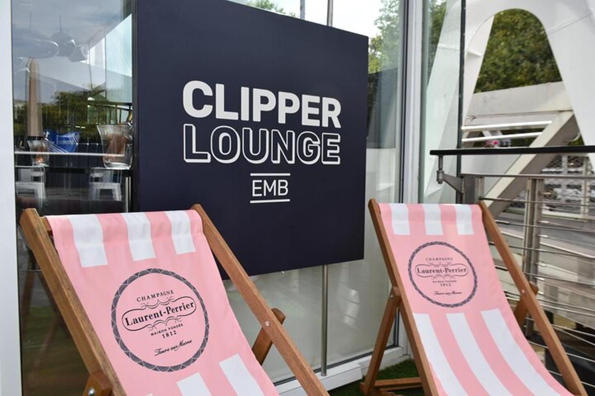két összecsukható szék egy Clipper Lounge tábla előtt