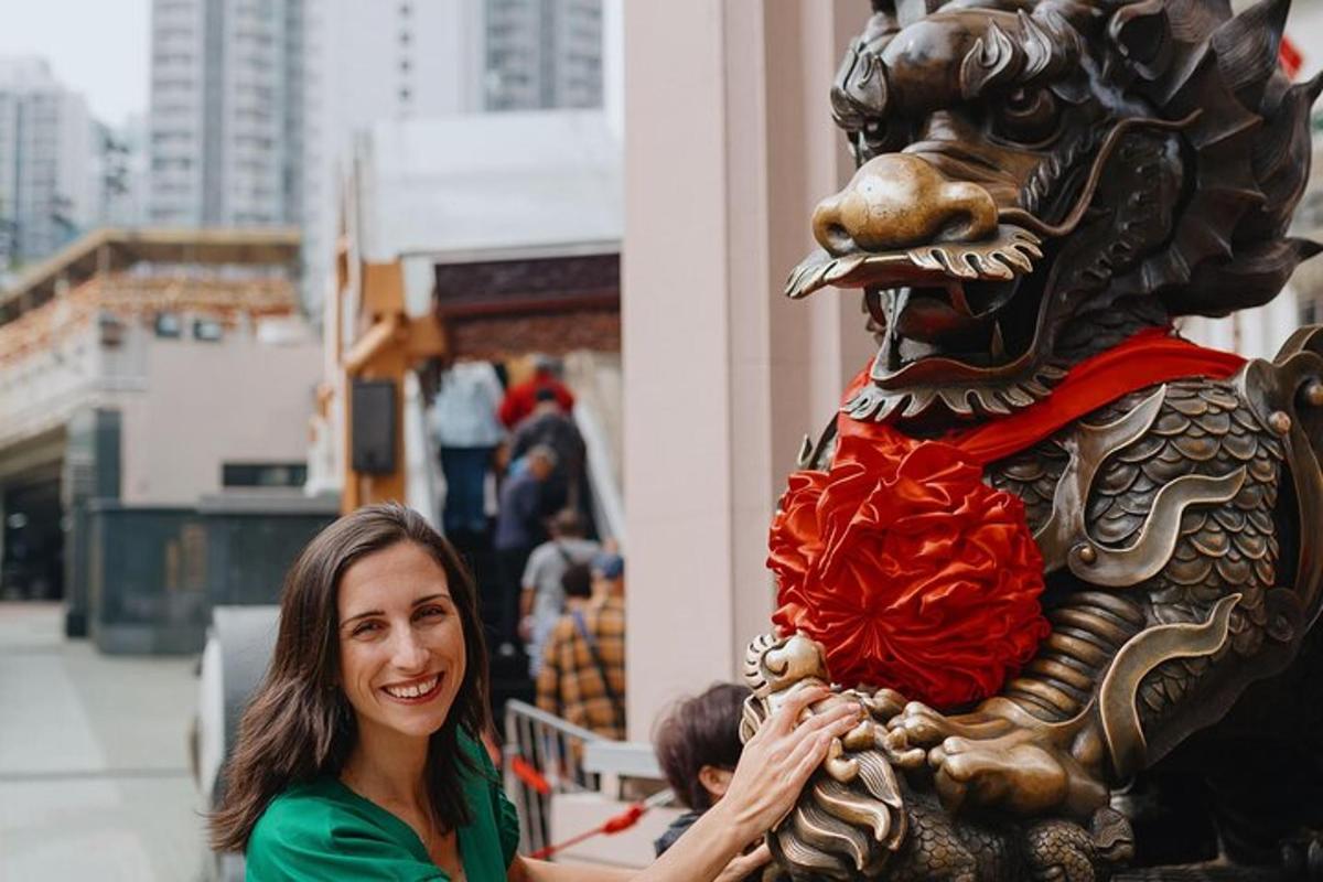 una donna in piedi accanto alla statua di un leone