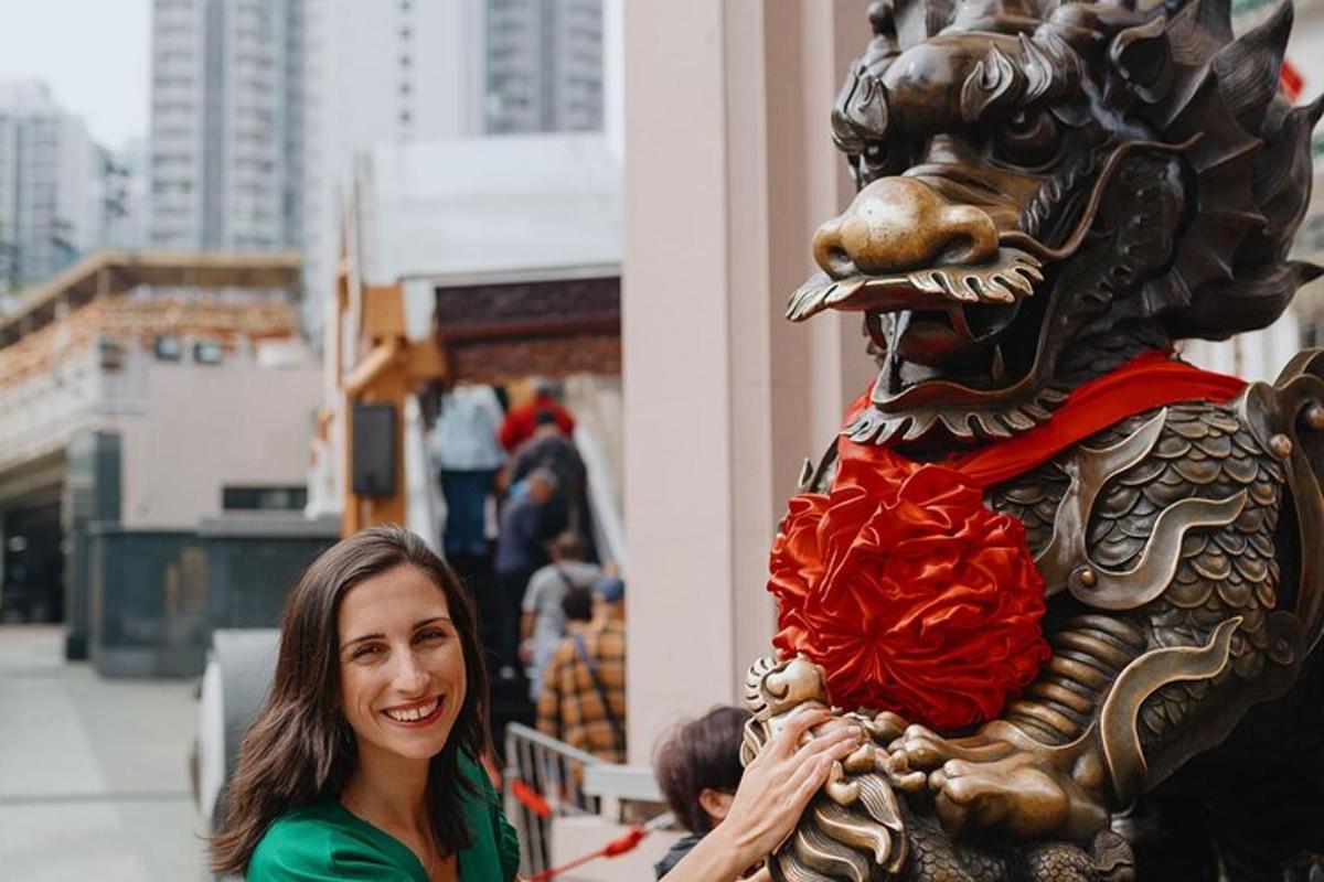 Una mujer parada junto a una estatua de un león.