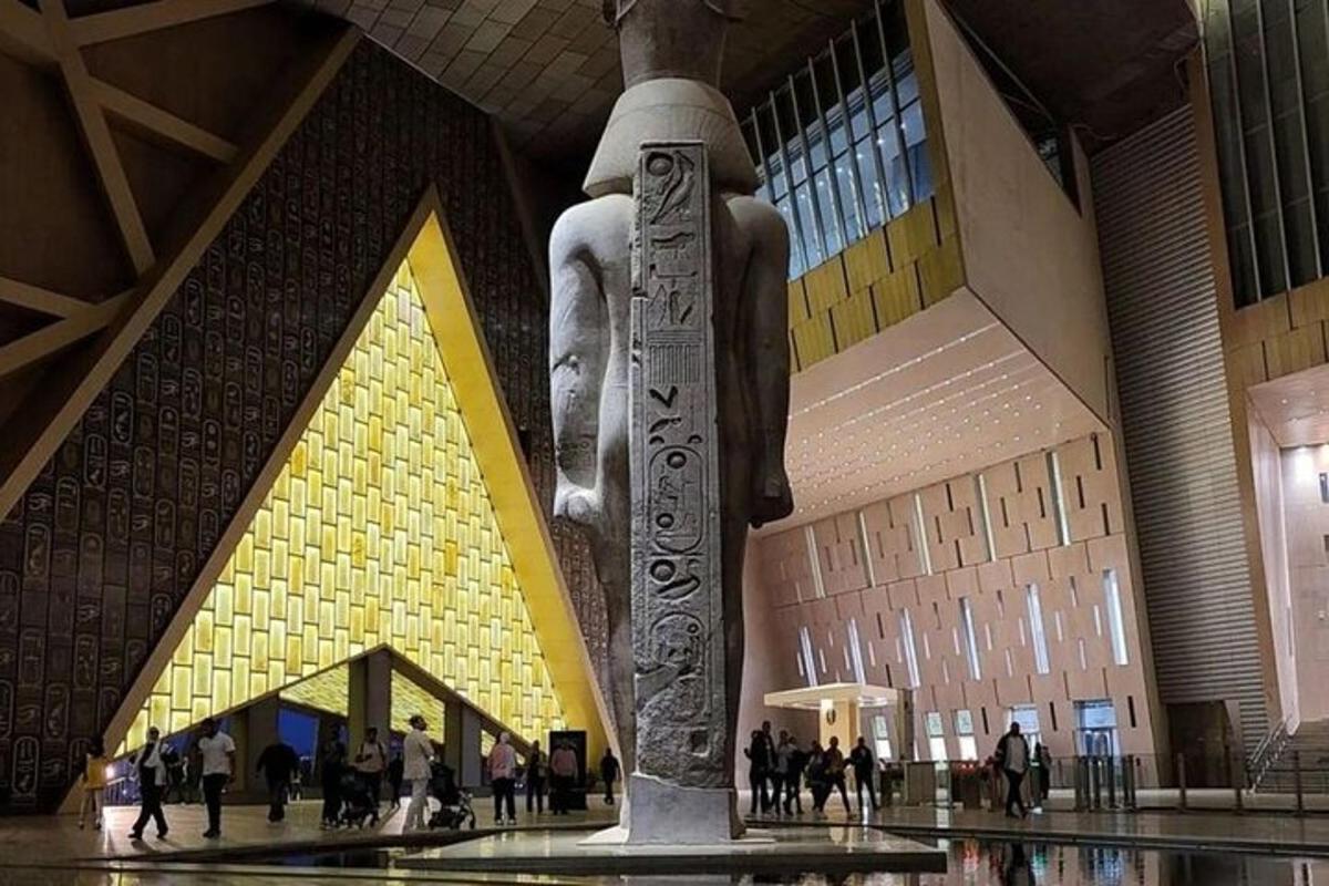 una statua in un edificio con persone che camminano intorno ad essa