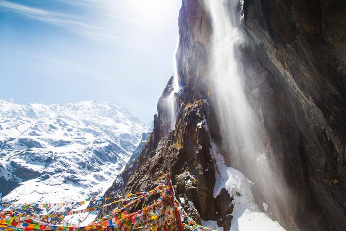 a group of people standing next to a waterfall on a mountain