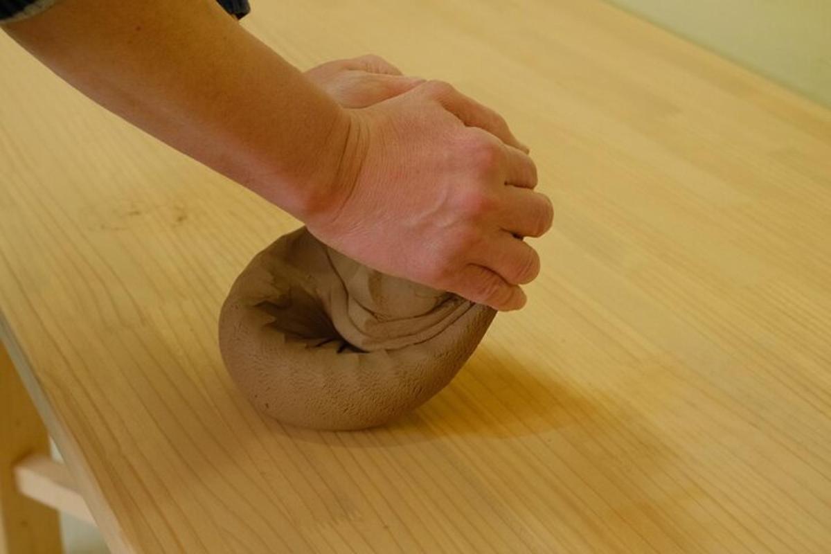 eine Person, die mit einer Holzschüssel auf einem Tisch spielt