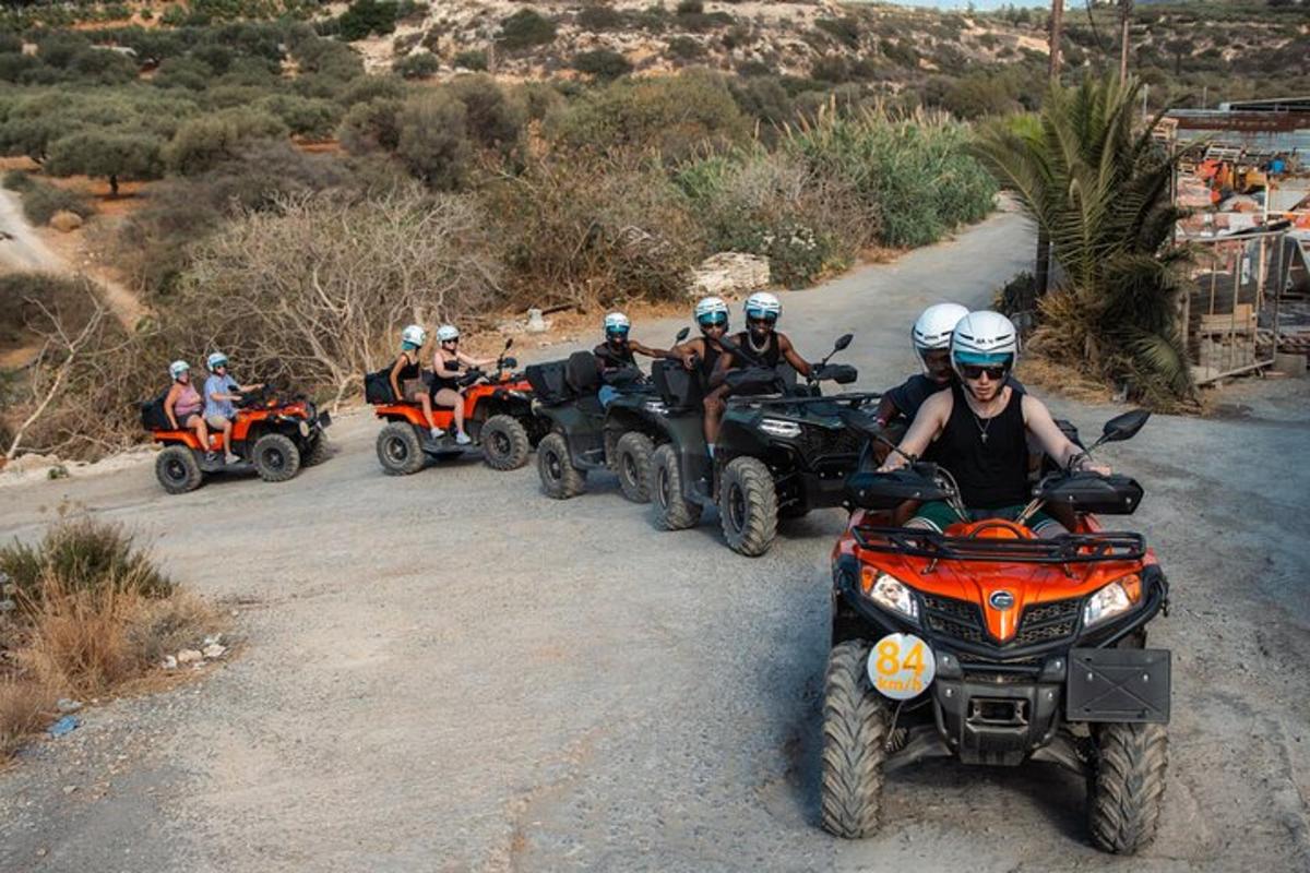 un grup de persones que condueixen quads per un camí de terra