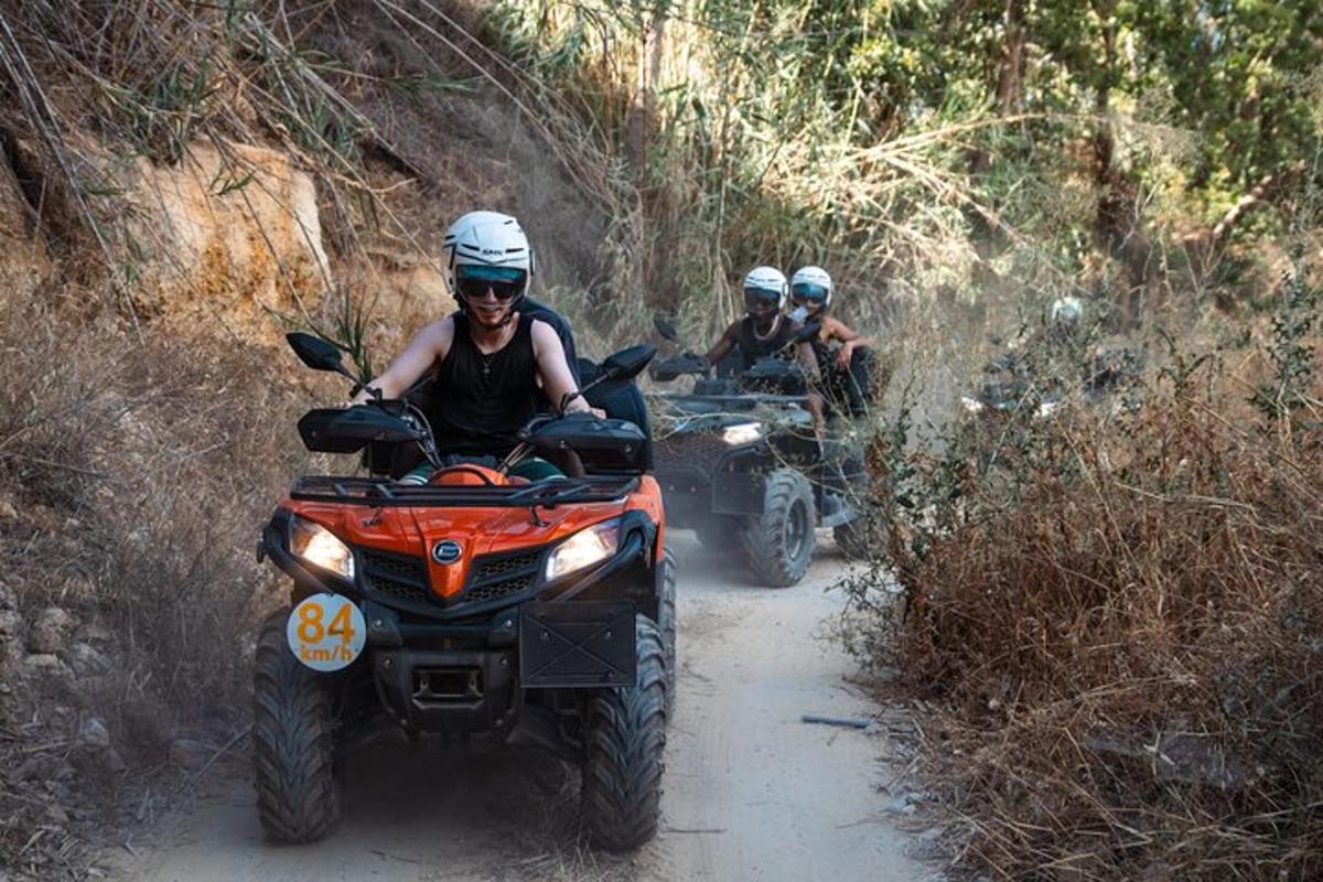 un grup de persones que condueixen quads per un camí de terra