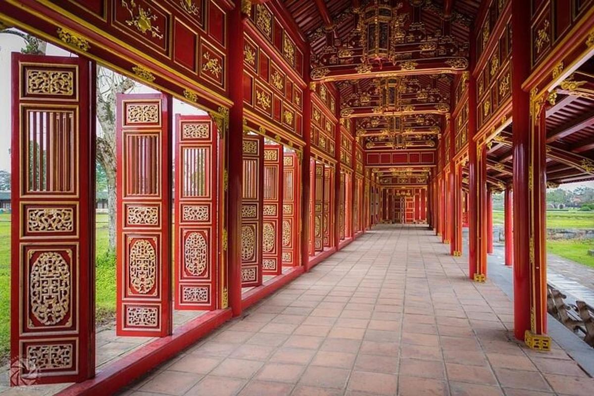 Un edificio con columnas rojas, un techo y una pasarela.