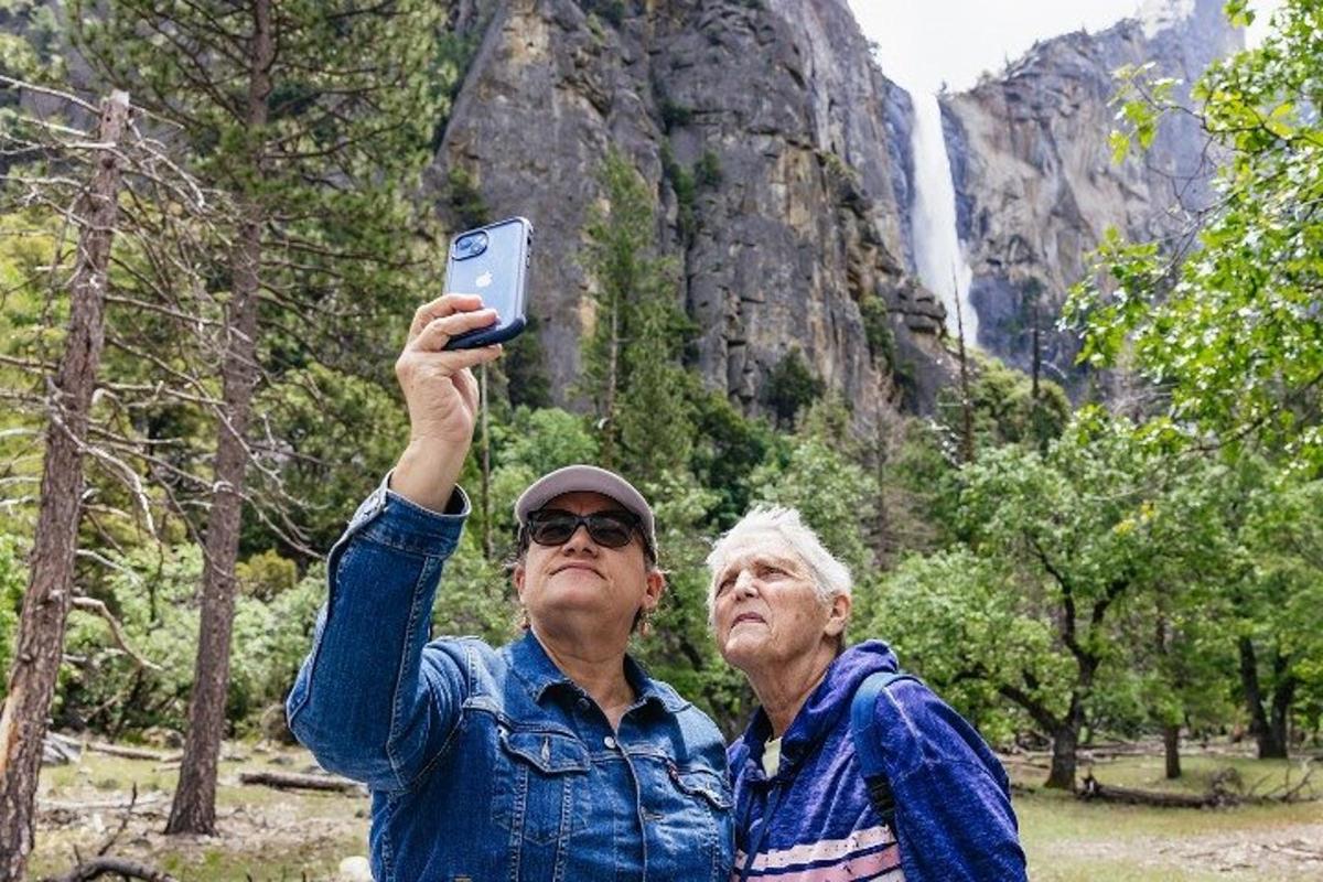 dois homens mais velhos tirando uma foto de uma cachoeira
