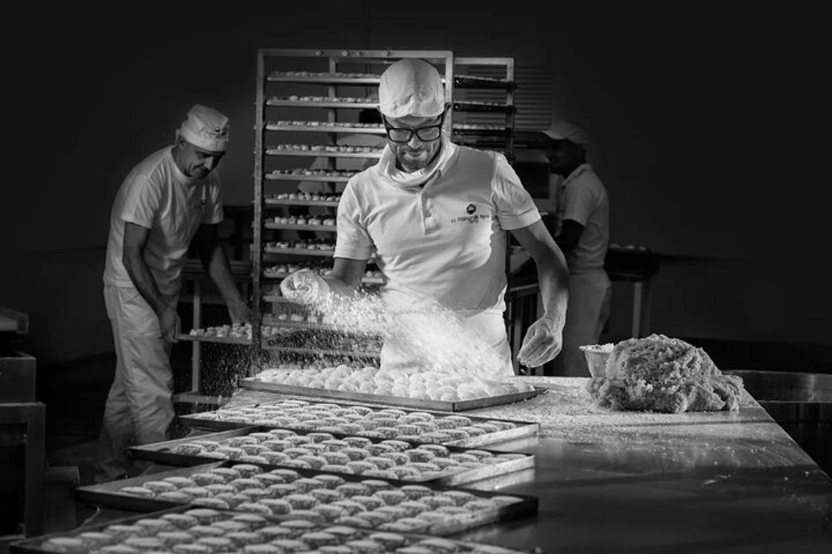 Un hombre en una cocina preparando comida en una mesa.