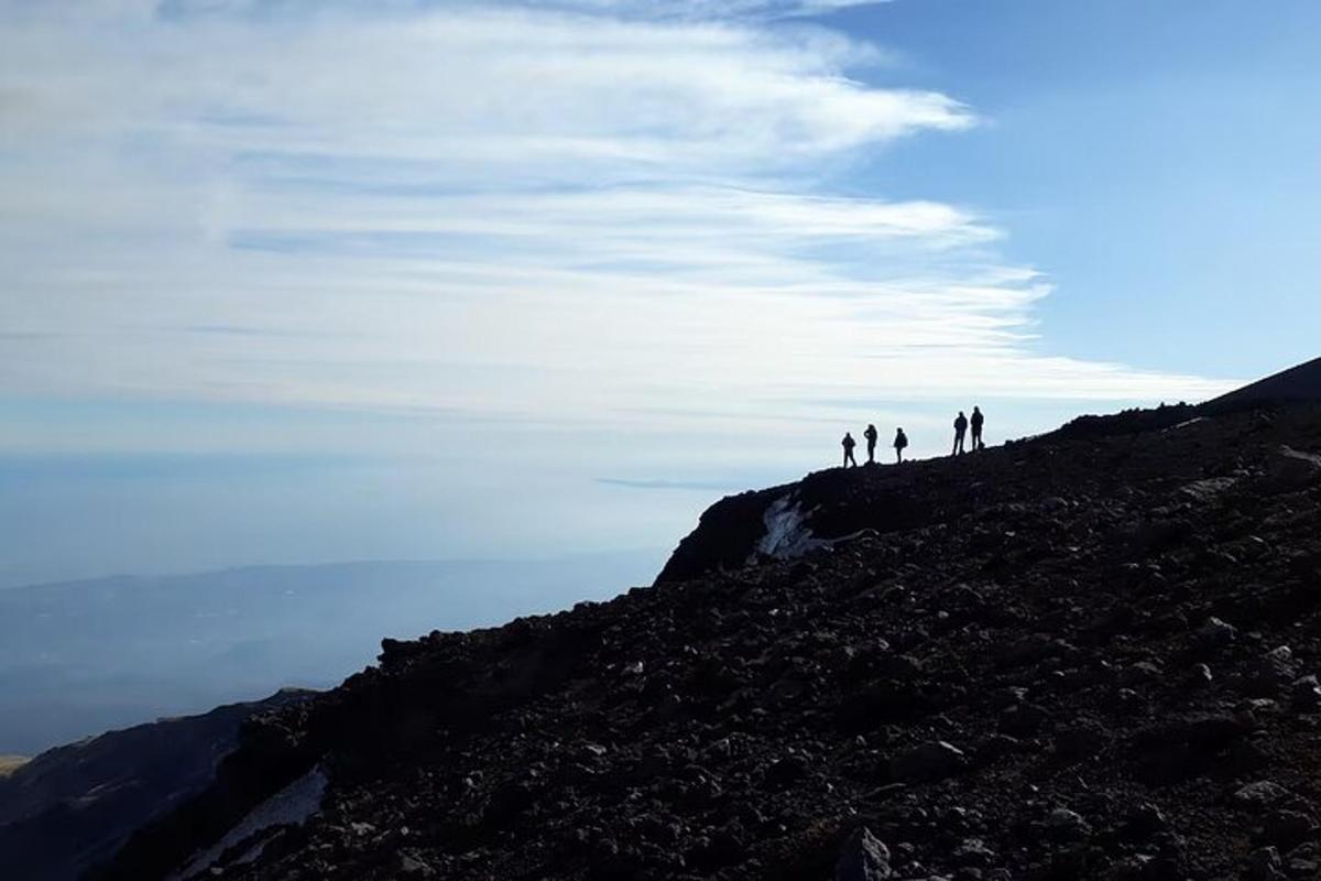 hópur fólks sem stendur uppi á fjallstindi