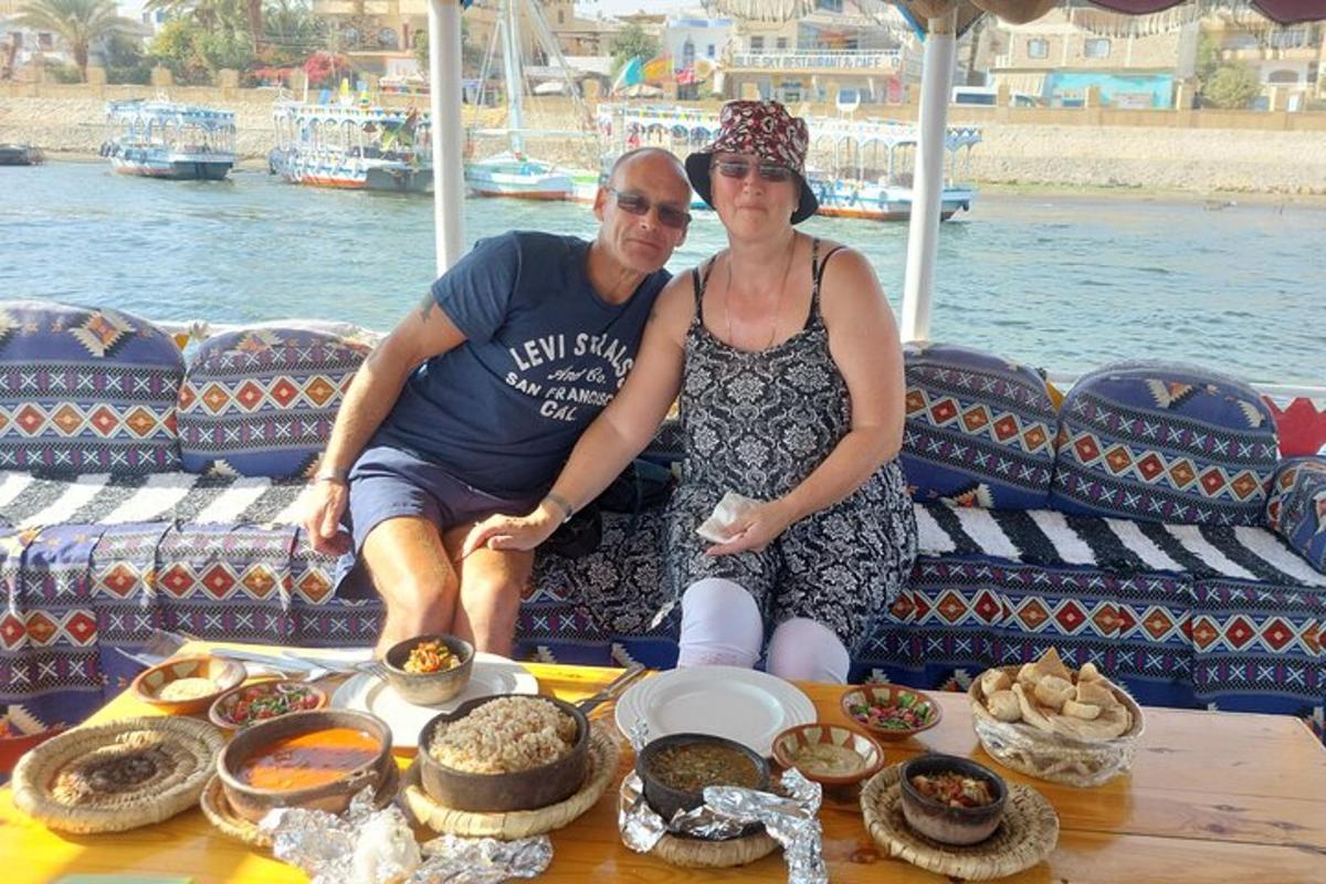 un uomo e una donna seduti su una barca con del cibo