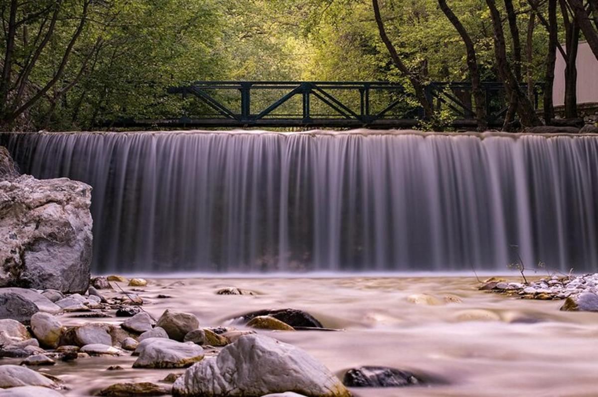 un ponte sopra un fiume con una cascata