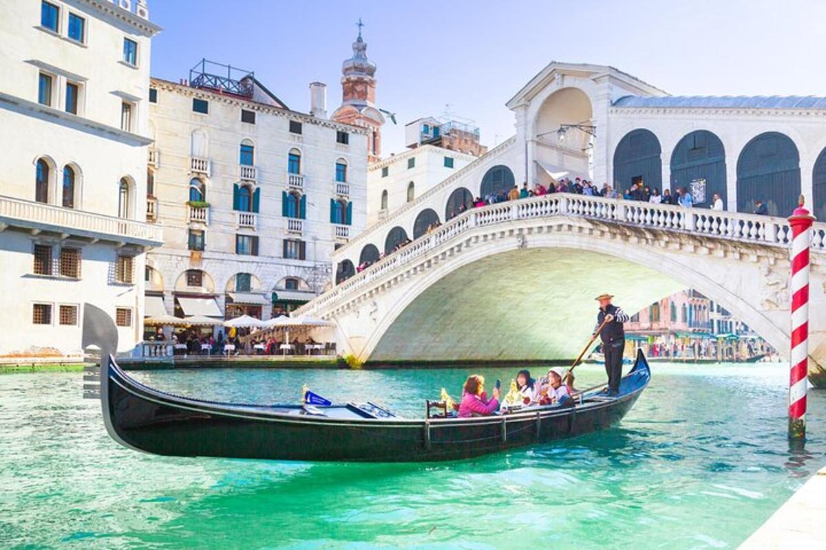 a group of people in a gondola in front of a bridge
