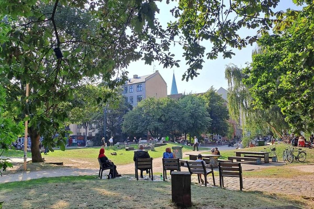 un grup de persones assegudes en bancs en un parc