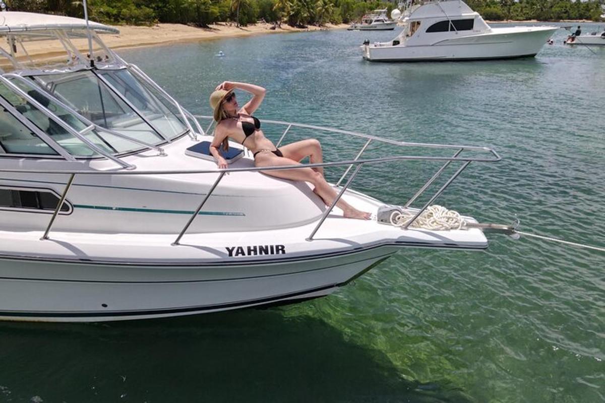 a woman in a bikini sitting on a boat in the water