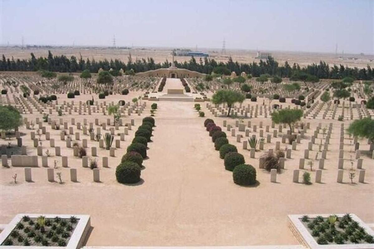 a cemetery with trees and bushes in a field