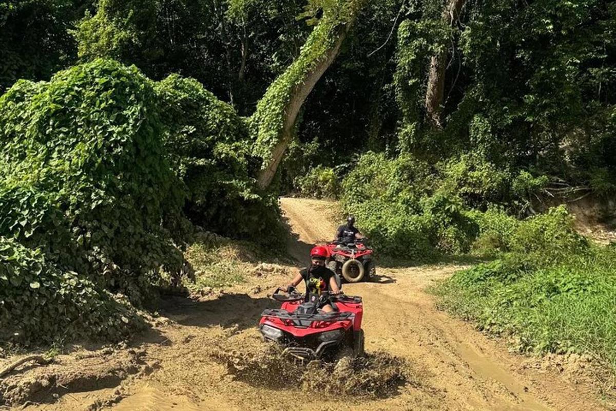 两个人骑着四轮摩托车在土路上行驶