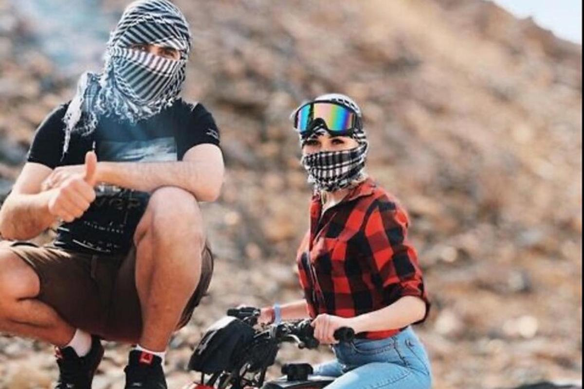 dva muži v helmách sedící na kole