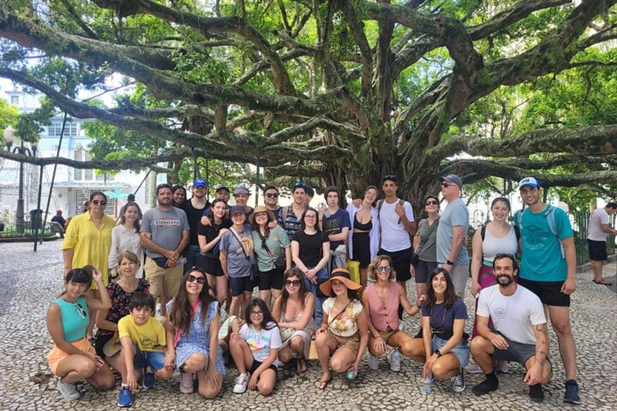 a group of people posing for a picture in front of a tree