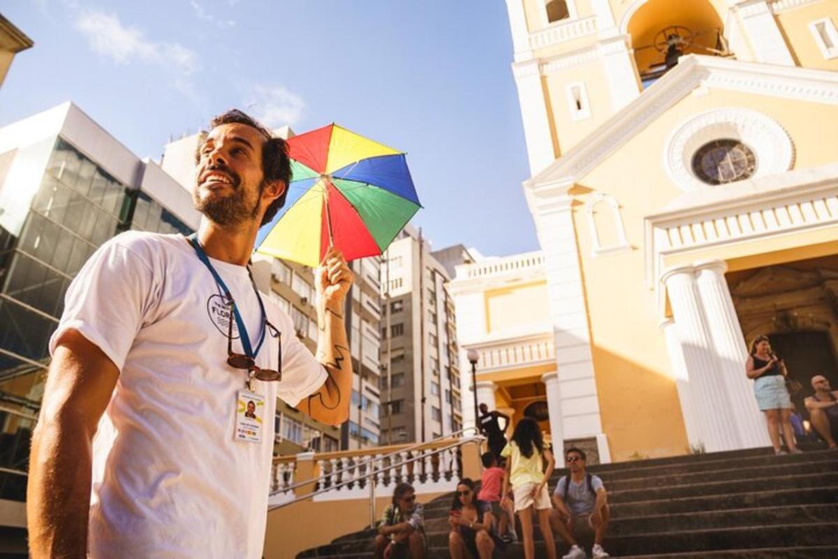 a man holding a colorful umbrella in front of a building