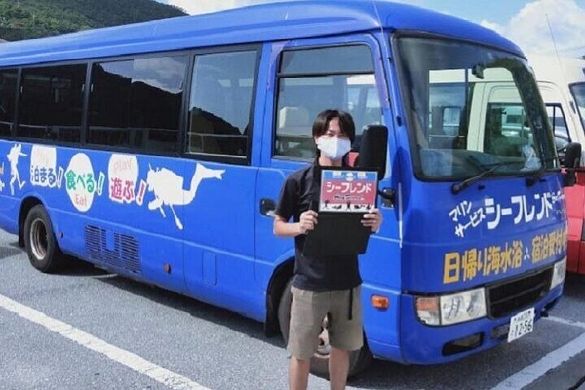 a person holding a sign in front of a bus